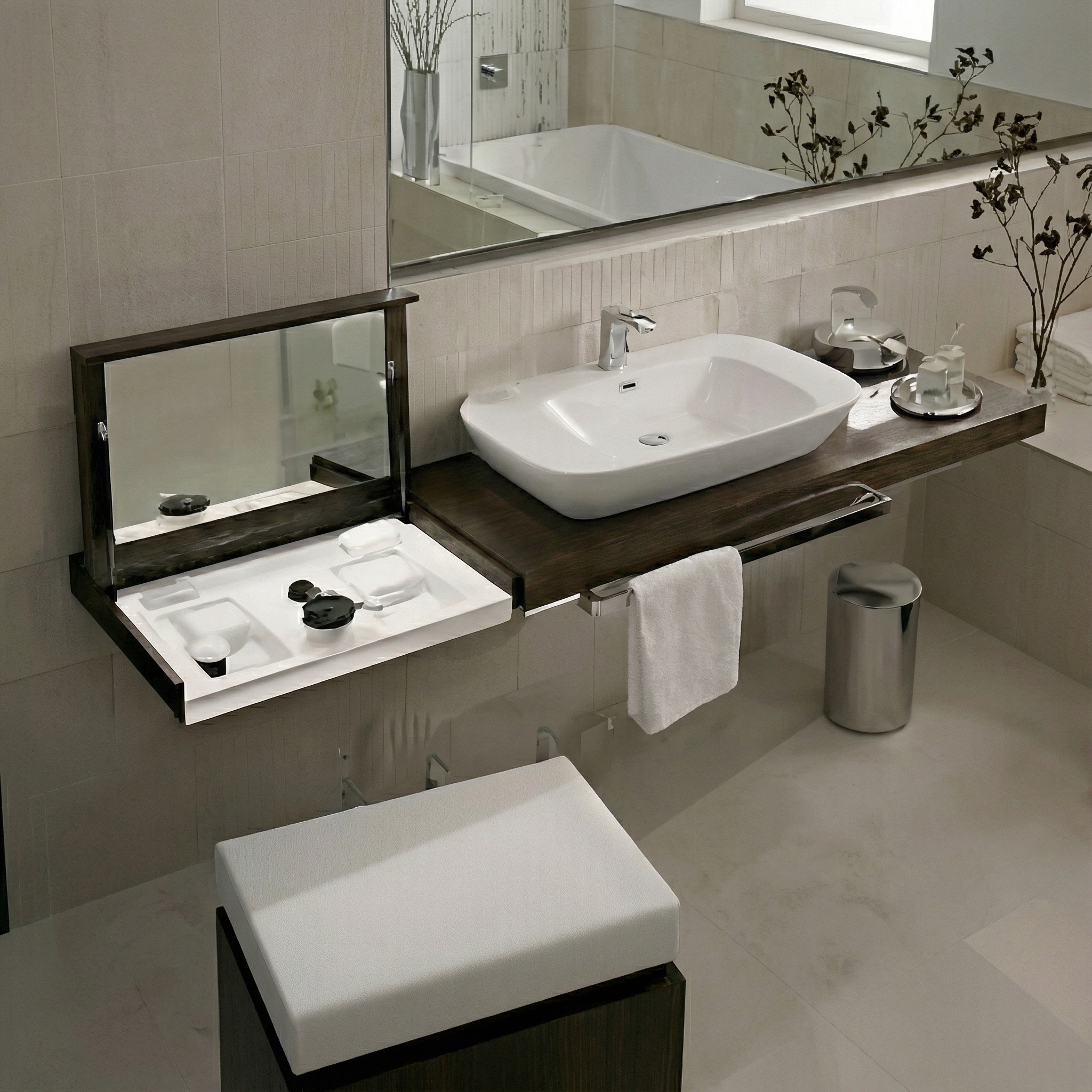 Modernes Badezimmer mit zwei Waschbecken. Links ein dunkelbrauner Waschtisch mit hochklappbarem Spiegel, der ein weißes Ablagefach für Kosmetika freilegt. Rechts ein weißes, rechteckiges Aufsatzwaschbecken mit Chromarmatur auf einer schwebenden dunkelbraunen Holzplatte. Ein weißes Handtuch hängt an einer Chromstange unter der Platte. Über den Waschtischen befindet sich ein großer Wandspiegel, der eine Badewanne und ein Fenster reflektiert. Die Wände sind hellbeige gefliest, der Boden hellgrau. Ein kleiner zylindrischer Mülleimer aus Chrom steht auf dem Boden. Im Vordergrund ist ein weiß gepolsterter Hocker mit dunklem Unterbau zu sehen.